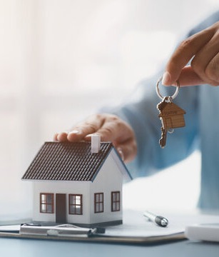Real estate agent handing house keys to a smiling couple